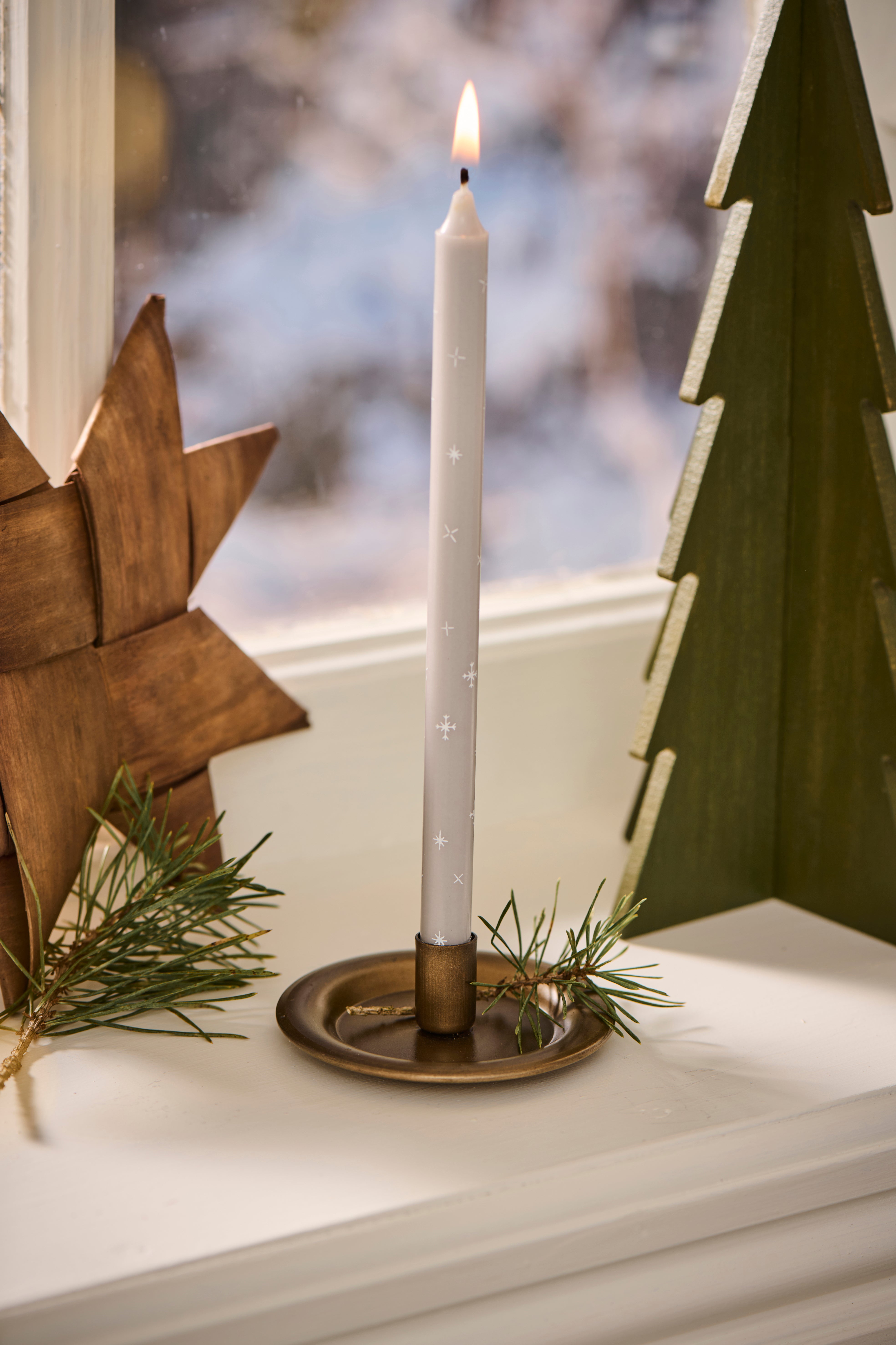 Dünne hohe Kerze mit Schneekristallen